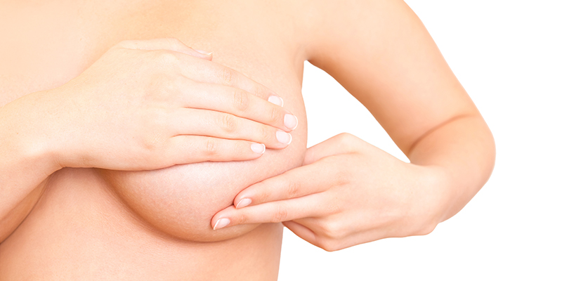 Frontal entblösste weibliche Brust. Die Brustwarze wird durch die rechte Hand der Statistin verdeckt. Die linke Hand ist auf zwei Finger ausgestreckt und deutet auf ein Abtasten der Brust hin. Symbolbild für das Brustzentrum Baselland.