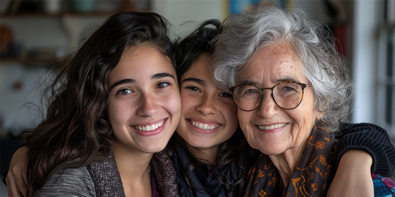 Drei Frauen unterschiedlichen alters schauen lachend und fröhlich in Richtung Kamera. Räpresentativ v.l. eine Mutter, dessen Tochter und Grossmutter. Die Enkeltochter in der Mitte hat ihren Arm über die Schultern der Grosmutter lässig hängend. (Symbolbild für die Frauenklinik des Kantonsspitals Baselland)